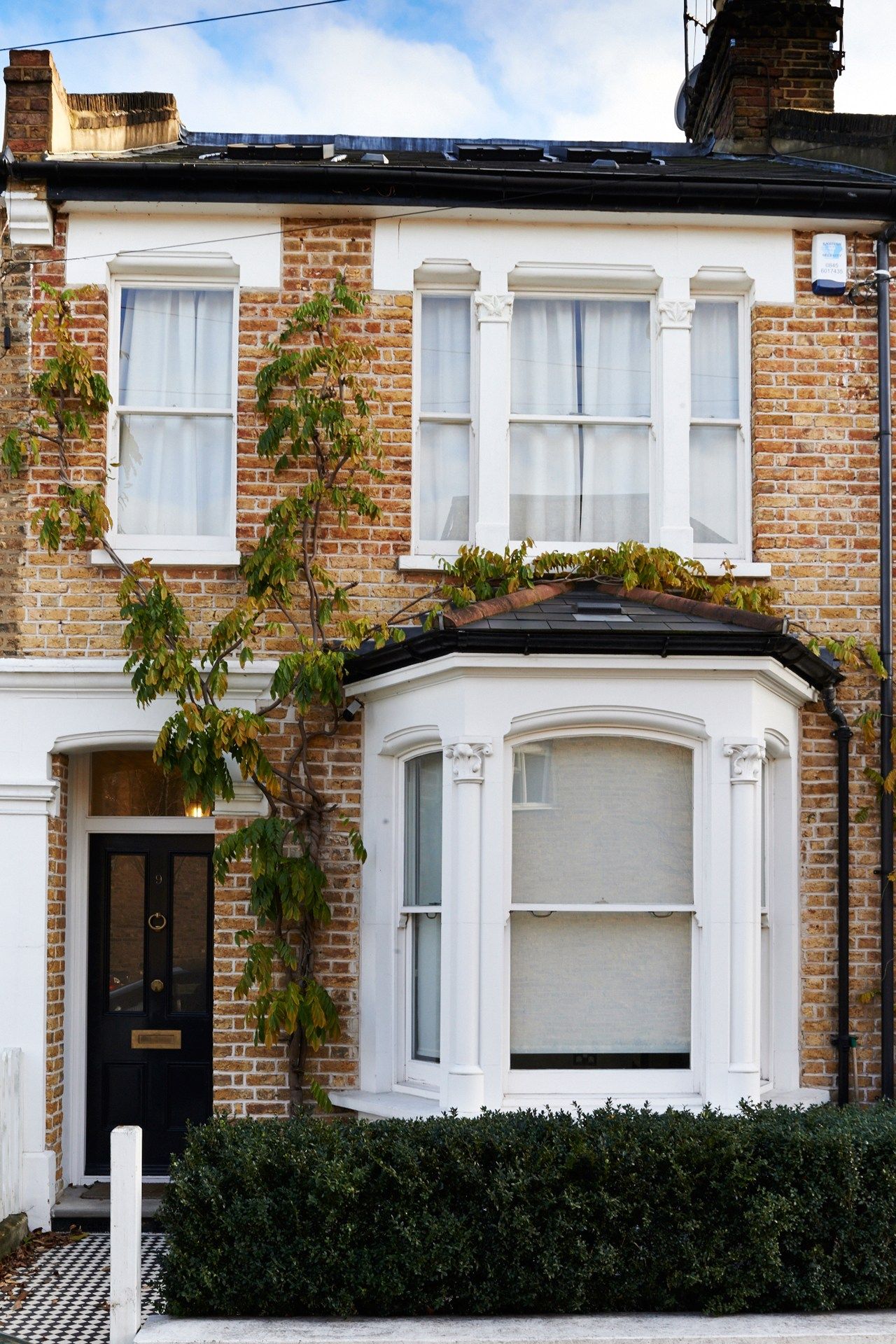 Period UK terrace with black guttering and downpipes